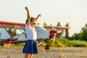 douce petite fille près de l'avion photo