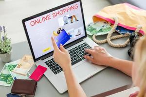 Jeune femme sur canapé shopping en ligne avec carte de débit photo