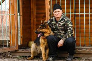 un homme dressant son chien de berger allemand à l'extérieur photo