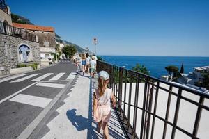 touriste familial marchant dans le célèbre village de positano en vacances en italie. photo