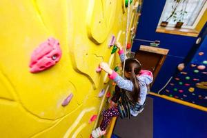 petite fille escaladant un mur de pierre photo