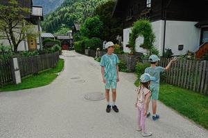 Trois enfants marchant dans la vieille ville de hallstatt, autriche. photo