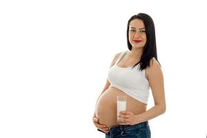 Jolie jeune femme brune enceinte posant isolé sur fond blanc photo