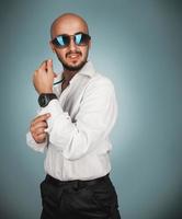 homme séduisant en lunettes de soleil et chemise blanche avec barbe en détournant les yeux photo