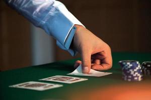 le croupier met les cartes sur la table avec un as dans sa manche photo