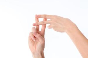 les mains des femmes montrent le geste avec les doigts croisés entre elles est isolé sur un fond blanc photo