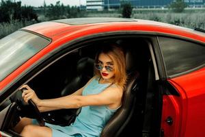 belle jeune femme en voiture rouge photo