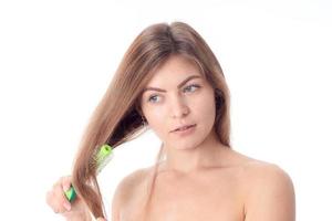 fille se peignant les cheveux et regarde vers isolé sur fond blanc photo