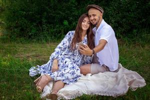 heureux jeune couple élégant fait selfie sur un téléphone portable à l'extérieur photo