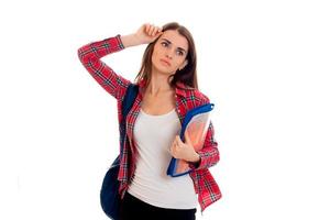 Jeune étudiante brune fatiguée avec sac à dos bleu isolé sur fond blanc photo