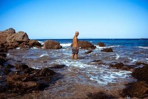 bel homme sur le rivage rocheux marin photo