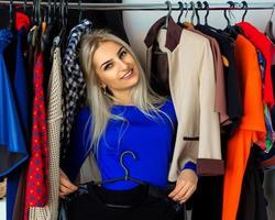 élégance jeune femme blonde dans un magasin de vêtements souriant à la caméra photo