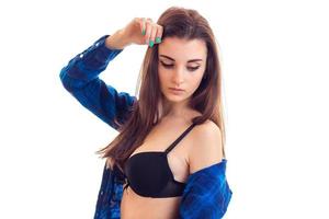 Une jeune fille séduisante en soutien-gorge noir et chemise regarde vers le bas isolé sur fond blanc photo