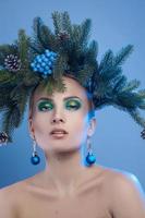 portrait en gros plan d'une belle jeune femme avec une couronne d'arbre de Noël sur la tête en regardant la caméra photo