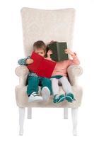 les enfants sont assis sur une chaise avec des livres photo