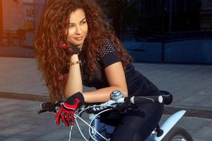 portrait d'une belle femme sportive brune à vélo photo