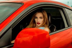 jeune fille au volant d'une voiture rouge photo