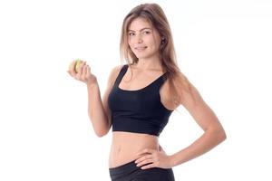 belle fille souriante debout sur le côté regarde au loin et tenant une pomme photo