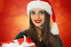 fille en bonnet de noel avec boîte-cadeau rouge photo