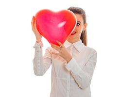 jeune femme heureuse avec des lèvres rouges se prépare à célébrer la Saint-Valentin avec le symbole du coeur en studio isolé sur fond blanc photo