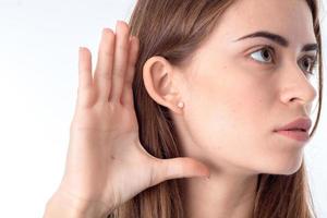 portrait d'une jeune fille qui tient la main près de l'oreille en gros plan photo