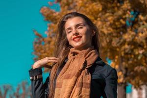 belle fille avec du rouge à lèvres ferma les yeux et souriant dans le parc photo