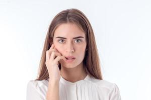 jeune fille regarde à droite et garde sa main près du visage isolé sur fond blanc photo