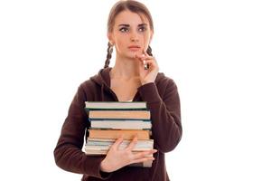 couvaison jeune fille-adolescente avec des nattes tient dans sa main beaucoup de livres et regarde vers photo