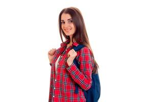 une jeune fille dans une chemise à carreaux rouge et avec un portefeuille sur les épaules de sourire et de regarder directement photo