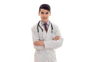 un jeune médecin avec stéthoscope et blouse blanche regardant la caméra photo