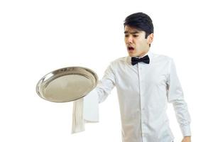 le jeune serveur laisse tomber bouche bée un plateau de vaisselle photo