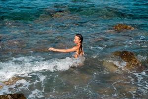 mignonne jeune fille s'amusant en mer photo