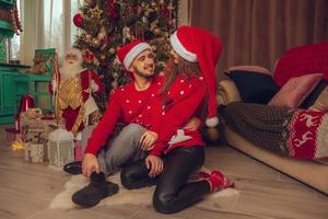 photo horizontale d'un joli couple amoureux célébrer le nouvel an et noël ensemble à la maison