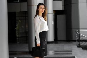 charmantes jeunes femmes de bureau debout dans la rue dans une chemise blanche photo