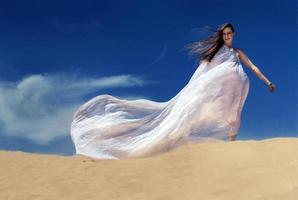 femme avec une robe volant dans le désert photo