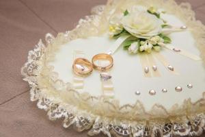 les anneaux de mariage en gros plan se trouvent sur un oreiller blanc photo