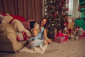 élégante mère et fille à l'arbre de noël photo