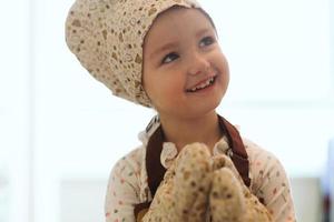 portrait de jolie petite fille homecook dans la cuisine blanche. photo