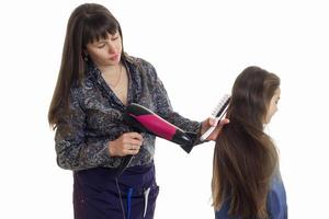 mère fait une coiffure à sa petite fille photo