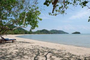 belle plage naturelle à phuket, thaïlande. plage blanche, ciel bleu. avec chaise de plage à partir de la plage photo