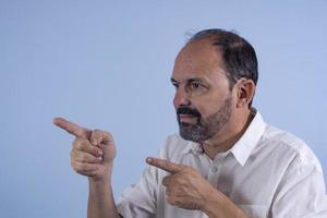 portrait d'homme barbu de 60 ans sur fond bleu photo