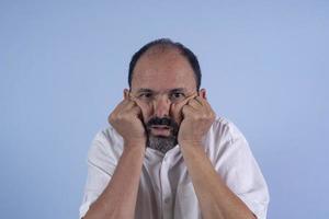 portrait d'homme barbu de 60 ans sur fond bleu photo