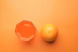 vue de dessus d'un verre de jus d'orange avec de la glace sur fond bleu photo