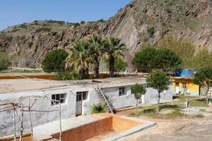 une maison pauvre dans un village au milieu des montagnes entre palmiers en turquie. photo