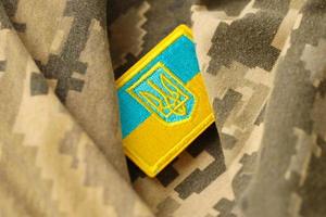 tissu de camouflage militaire avec le drapeau ukrainien sur un chevron d'uniforme photo