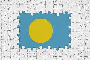 drapeau palau dans le cadre de pièces de puzzle blanches avec partie centrale manquante photo