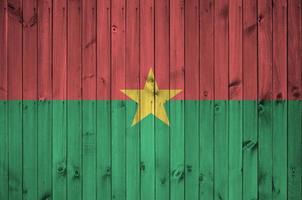 drapeau du burkina faso représenté dans des couleurs de peinture vives sur un vieux mur en bois. bannière texturée sur fond rugueux photo