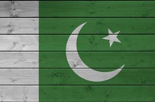 drapeau du pakistan représenté dans des couleurs de peinture vives sur un vieux mur en bois. bannière texturée sur fond rugueux photo