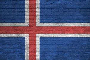 drapeau islandais représenté dans des couleurs de peinture sur un vieux mur de briques. bannière texturée sur fond de maçonnerie de gros mur de briques photo