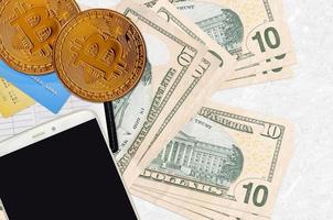 Billets de 10 dollars américains et bitcoins dorés avec smartphone et cartes de crédit. concept d'investissement en crypto-monnaie. minage ou commerce de crypto photo